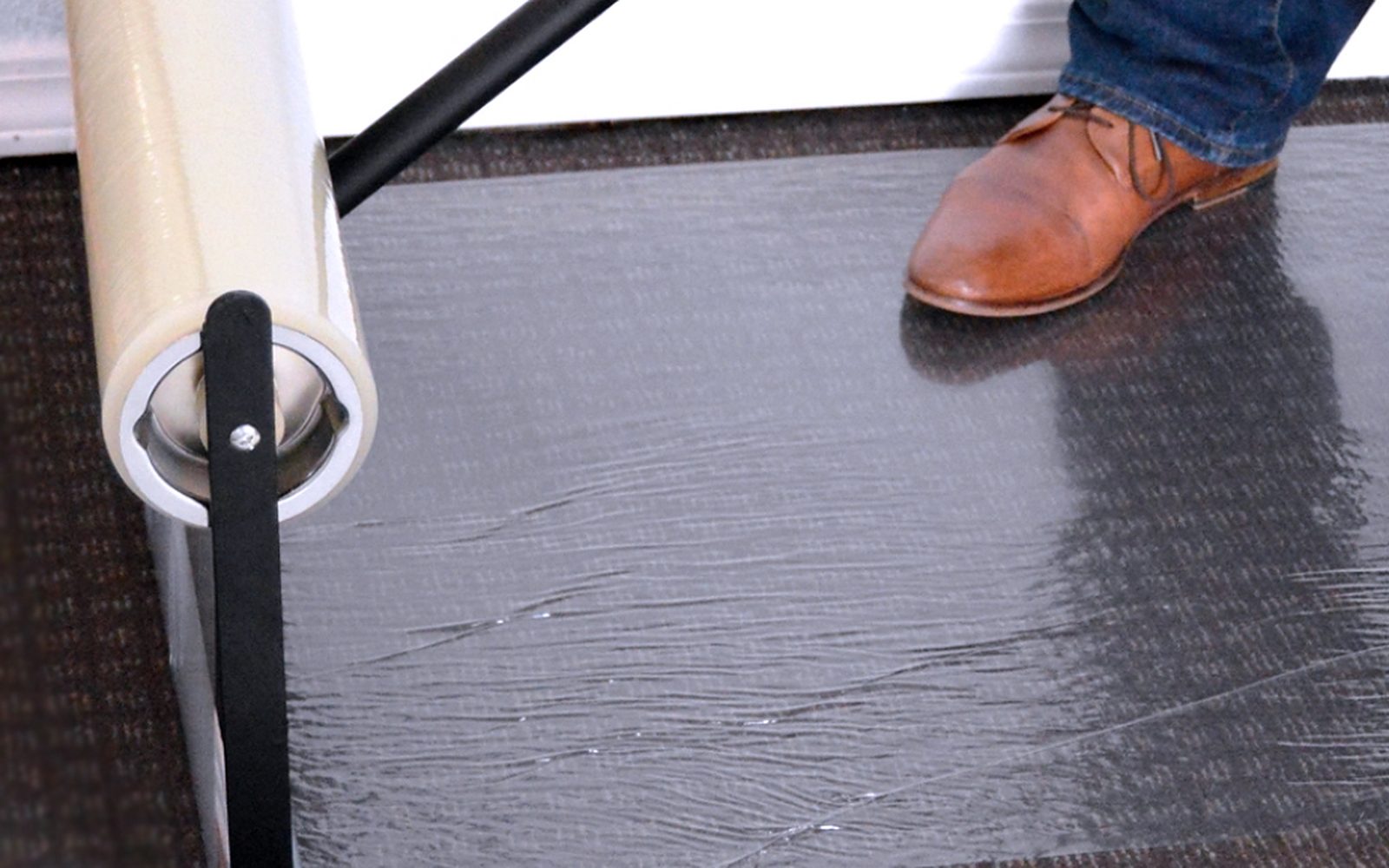 Protective film being applied to carpet with an applicator